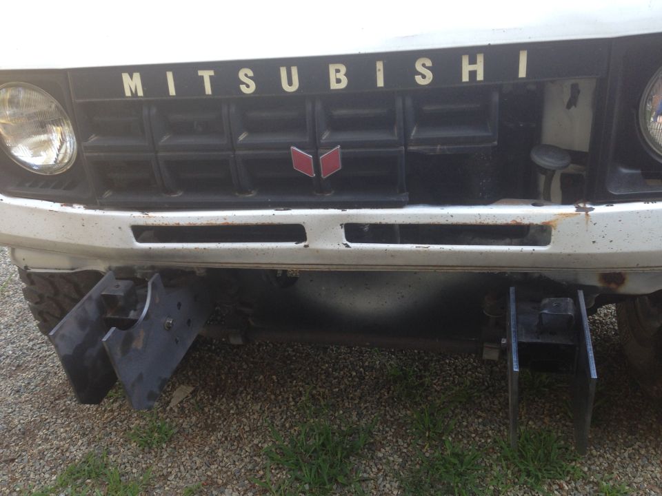 1990 Mitsubishi Montero front grille with MITSUBISHI lettering and emblem, custom bumper attachments visible