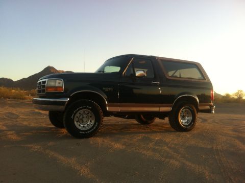 1994 Ford Bronco - This 1994 Ford Bronco is captured in a side profile against a desert backdrop at sunset.