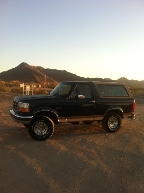 1994 Ford Bronco - Side view of a 1994 Ford Bronco in a desert landscape at sunset.