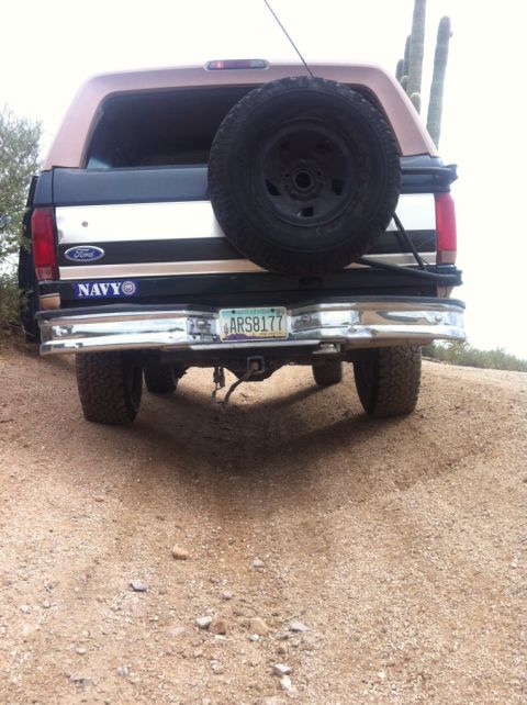 1994 Ford Bronco - Rear view of a 1994 Ford Bronco parked on a dirt road with cacti in the background.