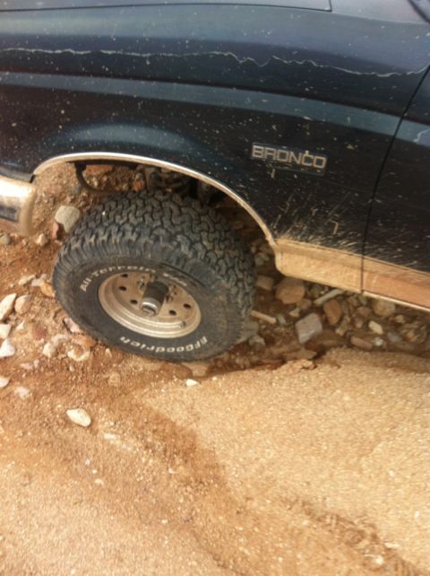 1994 Ford Bronco - A dark blue 1994 Ford Bronco navigates a rocky, off-road trail.