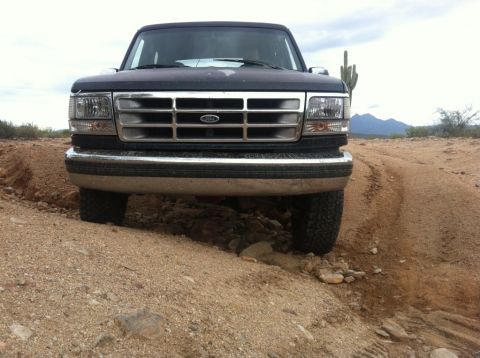 1994 Ford Bronco - This 1994 Ford Bronco is navigating a rough, unpaved track in a dry, arid environment.