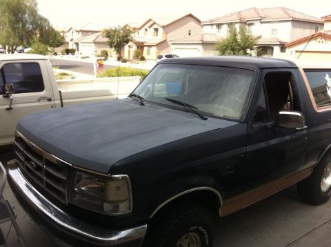 1994 Ford Bronco - This 1994 Ford Bronco is seen in a driveway with a white truck beside it.