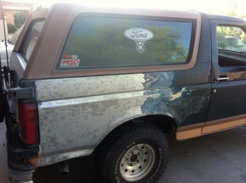 1994 Ford Bronco - This 1994 Ford Bronco shows significant body damage and primer on the rear quarter panel.