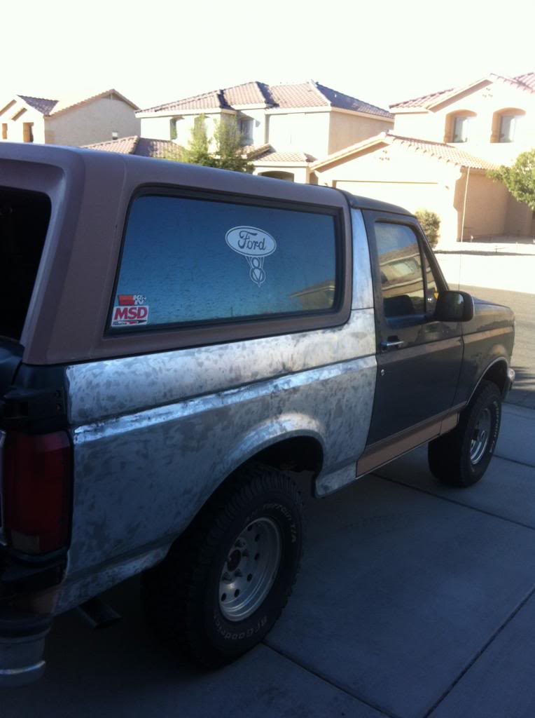 Ford Bronco with custom metal body panels and a Ford logo sticker on the rear window