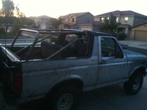 1994 Ford Bronco - This 1992 Ford Bronco is seen from a 3/4 front angle, modified with a roll cage and showing a dirty exterior.