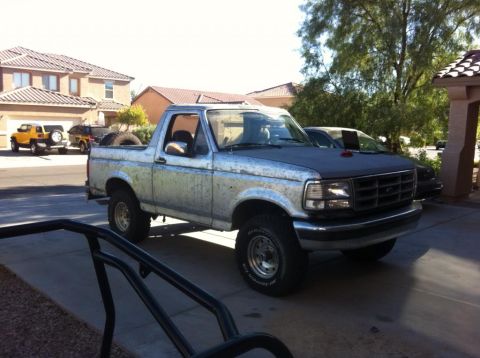 1994 Ford Bronco - This 1994 Ford Bronco is parked in a driveway with other vehicles visible.