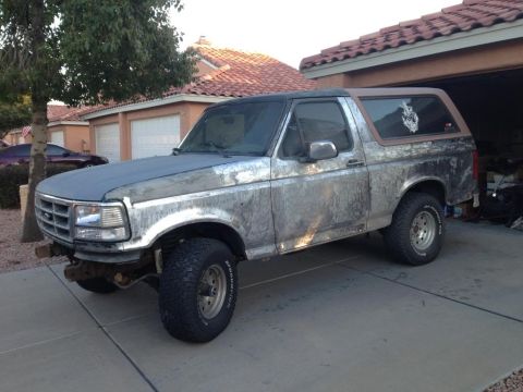 1994 Ford Bronco - This 1994 Ford Bronco shows significant wear on its exterior, with a weathered paint job and a lifted stance.