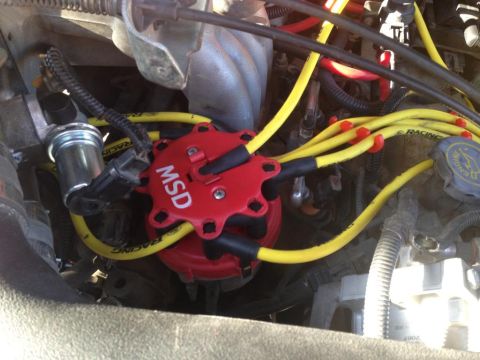 1994 Ford Bronco - Close-up of an engine's ignition system, an MSD distributor cap and yellow spark plug wires.