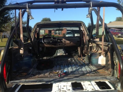 1994 Ford Bronco - The interior of a 1994 Ford Bronco shows a stripped-down cabin and a prominent roll cage.