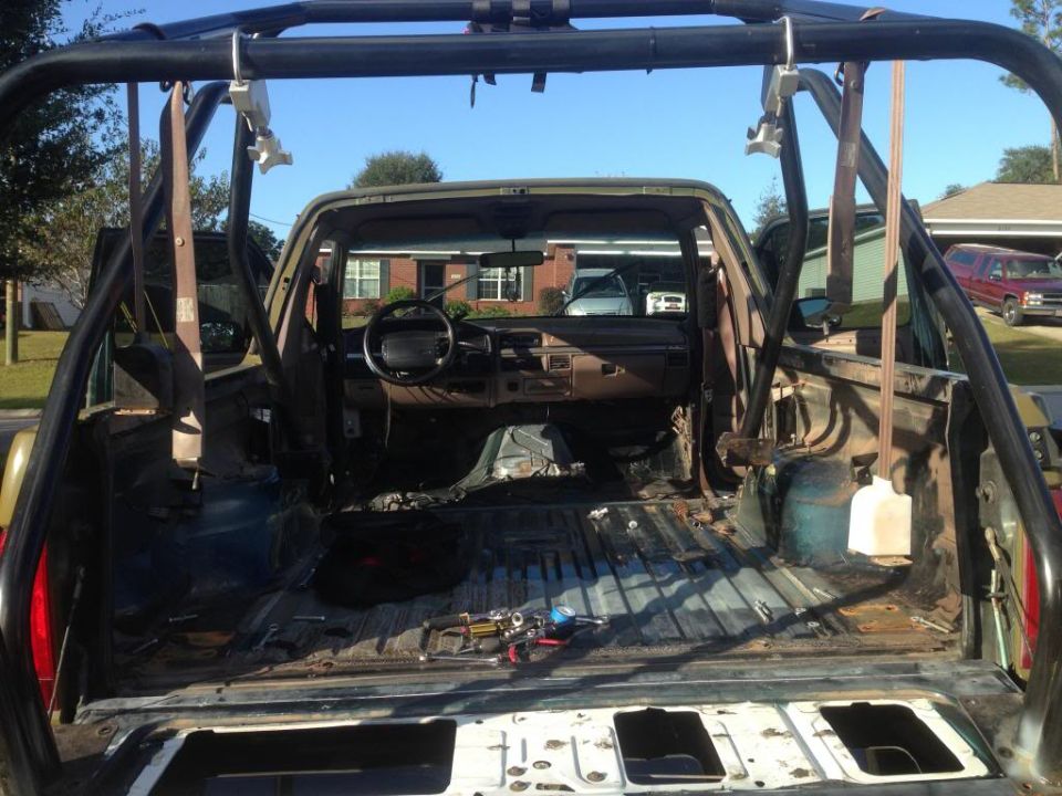 Interior of a 1994 Ford Bronco with roll cage and stripped interior