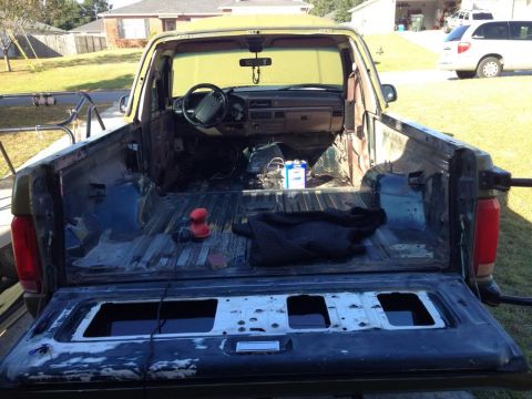 1994 Ford Bronco - Interior view of a 1992 Ford F-Series truck, with the bed stripped down and a sander visible.