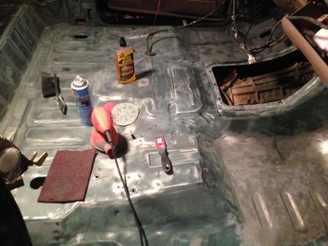 1994 Ford Bronco - Cleaning supplies and tools are laid out on the stripped interior floor of a vehicle.