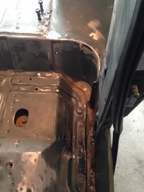1994 Ford Bronco - The interior floor pan of a vehicle is shown, with visible rust and signs of repair work.