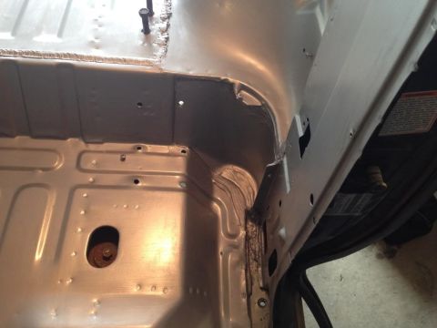 1994 Ford Bronco - The bare metal interior floor pan shows structural details and a central bolt, suggesting a work-in-progress or restoration.