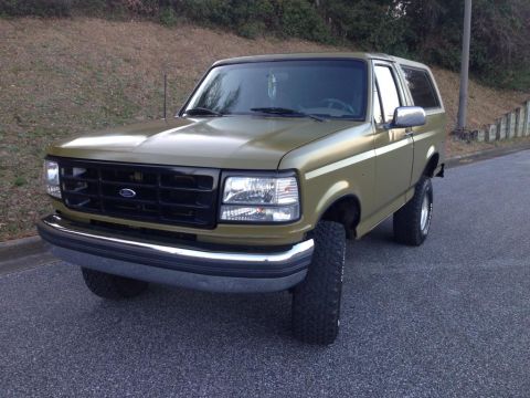 1994 Ford Bronco - This olive green Ford Bronco is shown from a three-quarter front view.