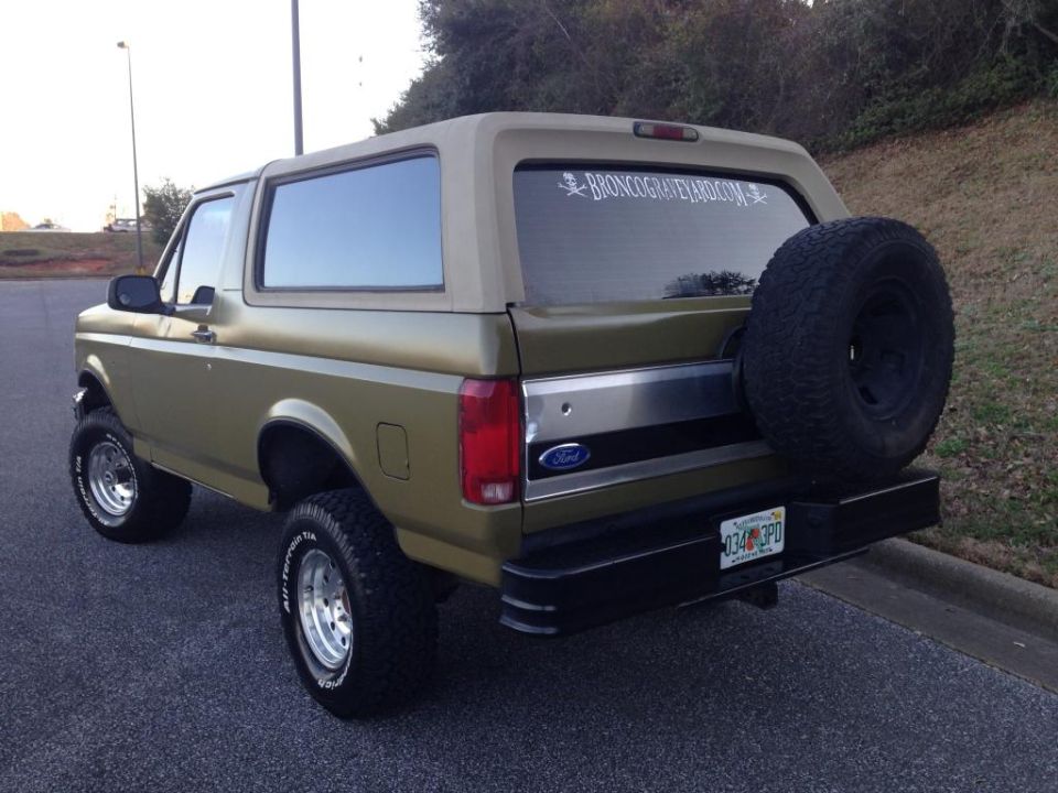 1994 Ford Bronco with spare tire mounted on rear door, tan top