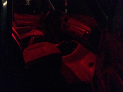 1994 Ford Bronco - Interior view of a vehicle illuminated by red lights, with visible seating and dashboard elements.