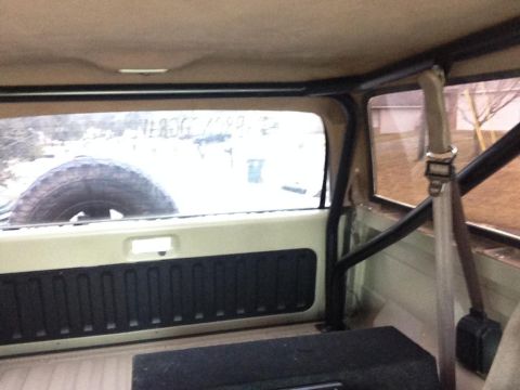 1994 Ford Bronco - The interior of a 1994 Ford Bronco, a roll cage and a spare tire mounted behind the rear seat.
