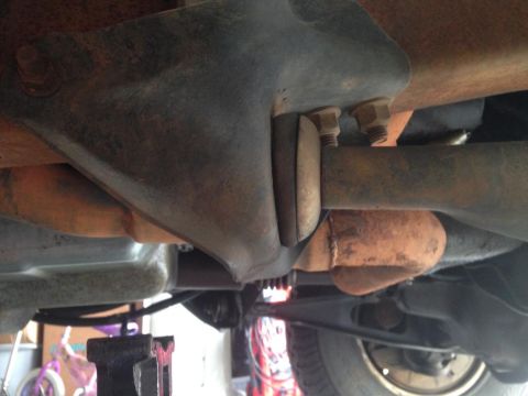 1994 Ford Bronco - A close-up shot of the undercarriage reveals rusted metal parts and suspension components.