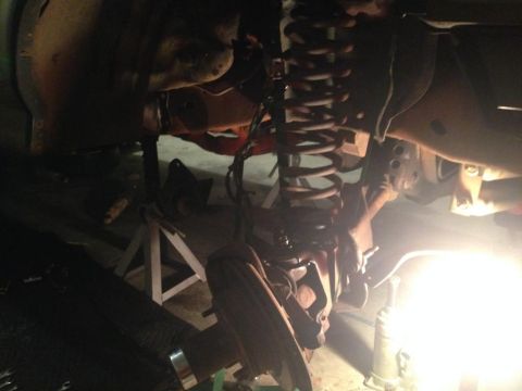 1994 Ford Bronco - Vehicle suspension system undergoing maintenance or repair, with parts visible on jack stands.