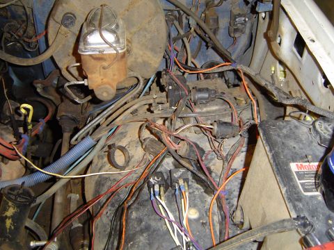 1989 Ford Bronco - Close-up of a complex engine bay wiring harness and brake fluid reservoir.