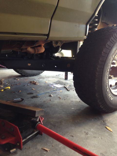 1994 Ford Bronco - The underside of a vehicle is shown with a jack and tools on the ground, suggesting maintenance work is in progress.