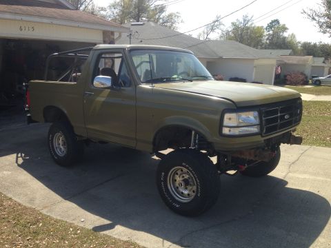 1994 Ford Bronco - Olive green 1994 Ford Bronco modified with a roll cage and lifted suspension.
