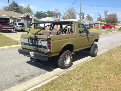1994 Ford Bronco - This 1994 Ford Bronco features a prominent roll cage and a spare tire mount on the rear.