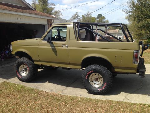 1994 Ford Bronco - This modified Ford Bronco features a roll cage and large off-road tires, suggesting a build year earlier than 1994.