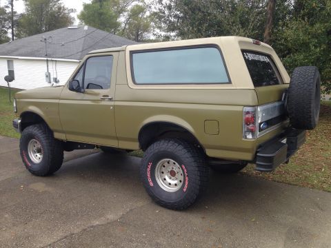 1994 Ford Bronco - This lifted Ford Bronco features off-road tires and a spare tire mounted on the rear tailgate.