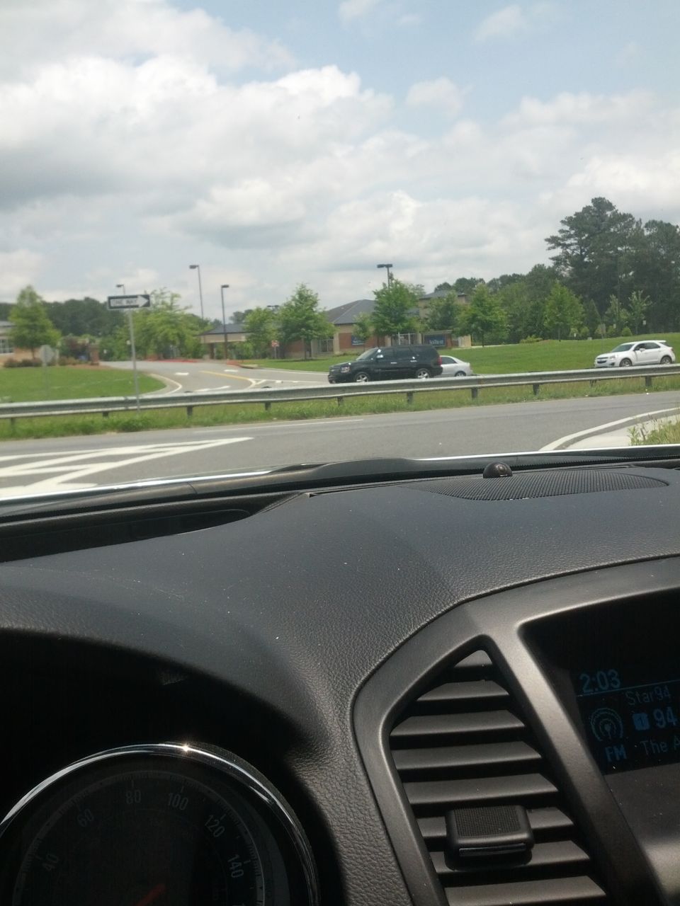 View from car interior showing dashboard, road, and other vehicles on a cloudy day