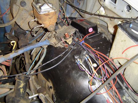 1989 Ford Bronco - The complex wiring harness in the engine bay is visible, along with the brake master cylinder and an aftermarket ignition control module.