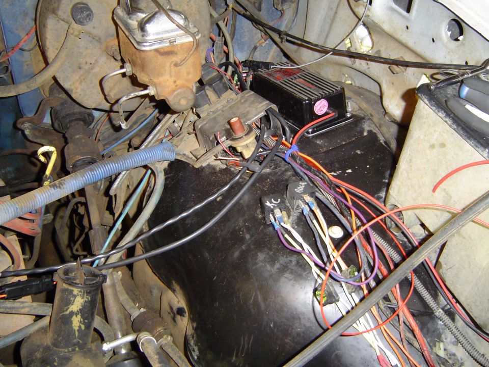 MSD ignition box and starter solenoid on inner fender with loose wiring harness in engine bay