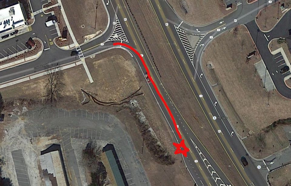 Aerial shot of a road with a red arrow indicating a turn