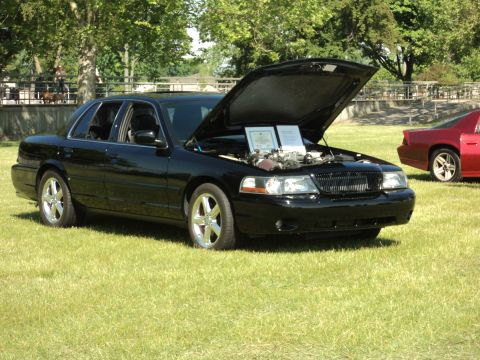 2004 Mercury Grand Marquis - A black 2004 Mercury Grand Marquis is displayed with its hood open, showing the engine compartment.
