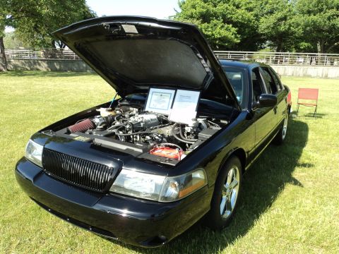 2004 Mercury Grand Marquis - 2004 Mercury Grand Marquis on display with its engine exposed, two informational documents.