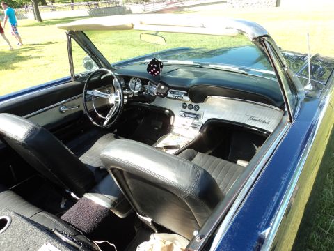 2004 Mercury Grand Marquis - The interior of a classic blue convertible, identified by "Thunderbird" script on the dash, is shown with fuzzy dice.