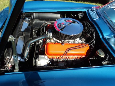 2004 Mercury Grand Marquis - The engine bay of a blue 1967 Corvette features a prominent 427 badge on the chrome air cleaner.