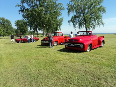 2004 Mercury Grand Marquis - Outdoor car show with several classic red trucks and a convertible on display.