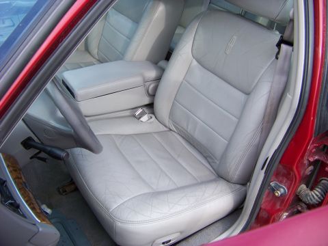 1999 Mercury Grand Marquis - Interior view of a car with light gray leather seats and a Lincoln emblem on the headrest.