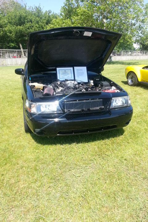 2004 Mercury Grand Marquis - A black 2004 Mercury Grand Marquis is displayed with its hood up, revealing the engine and informational documents.
