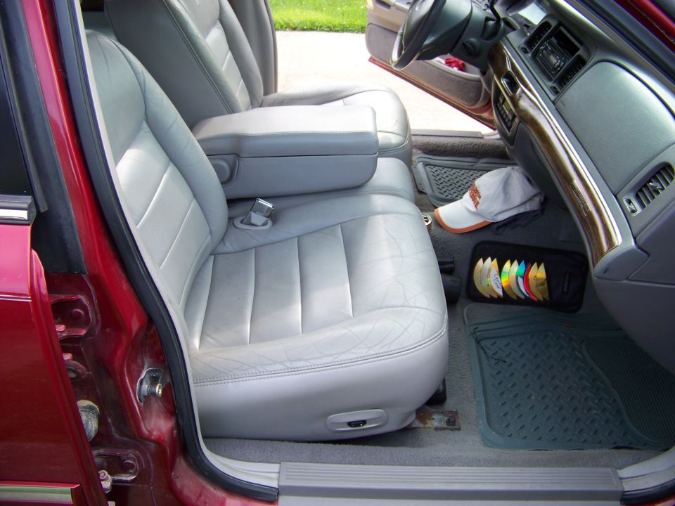 Interior view of light grey leather seats and dashboard in a red car