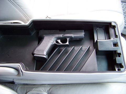 1999 Mercury Grand Marquis - A Glock pistol is stored in the center console of a vehicle.
