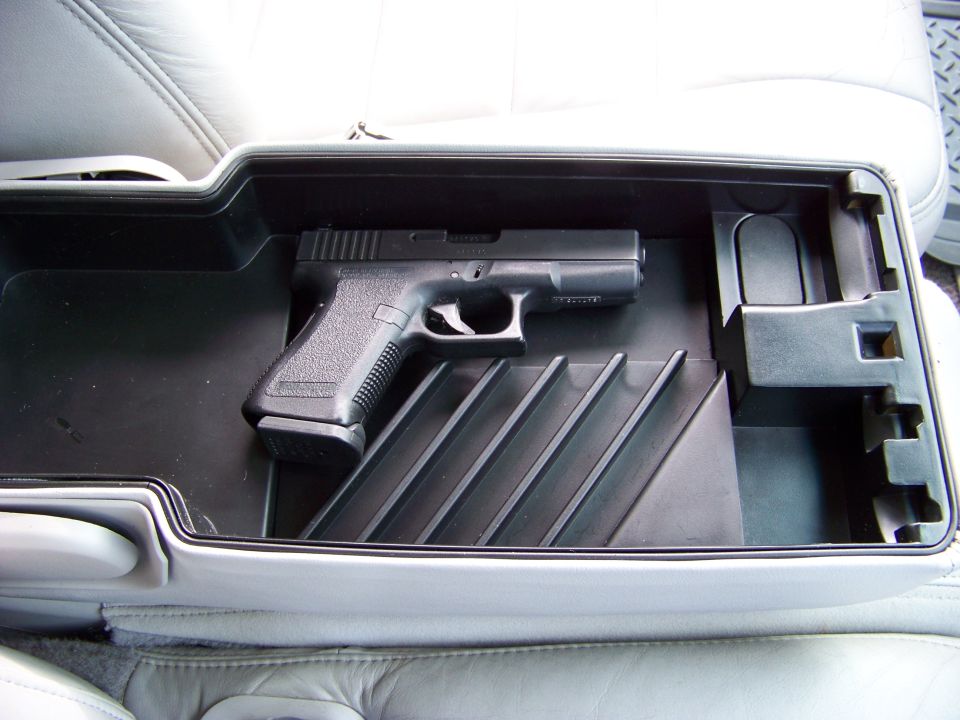Glock pistol in open center console storage compartment