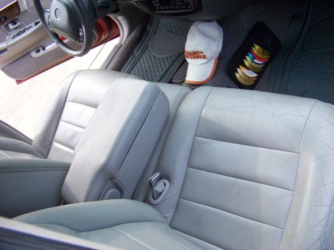 1999 Mercury Grand Marquis - The interior of a car features light-colored leather seats and a view of the dashboard and steering wheel.