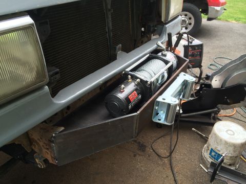 1991 Ford F-250 - A custom-fabricated bumper for a 1991 Ford F-250 holds a winch, with another vehicle visible behind.