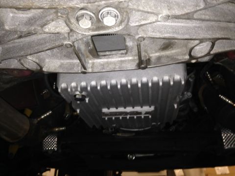 2010 Dodge Challenger - Close-up view of the underside of a vehicle, focusing on the transmission pan and associated components.