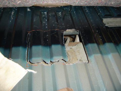 1996 Ford Bronco - A hole has been cut into the floor of a vehicle, revealing the structure beneath.
