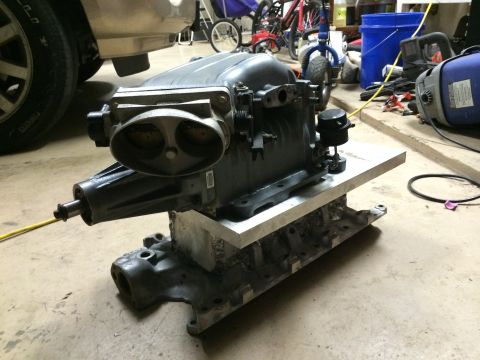 1996 Ford Bronco - A Ford supercharger assembly is shown mounted on a metal base in a garage setting.